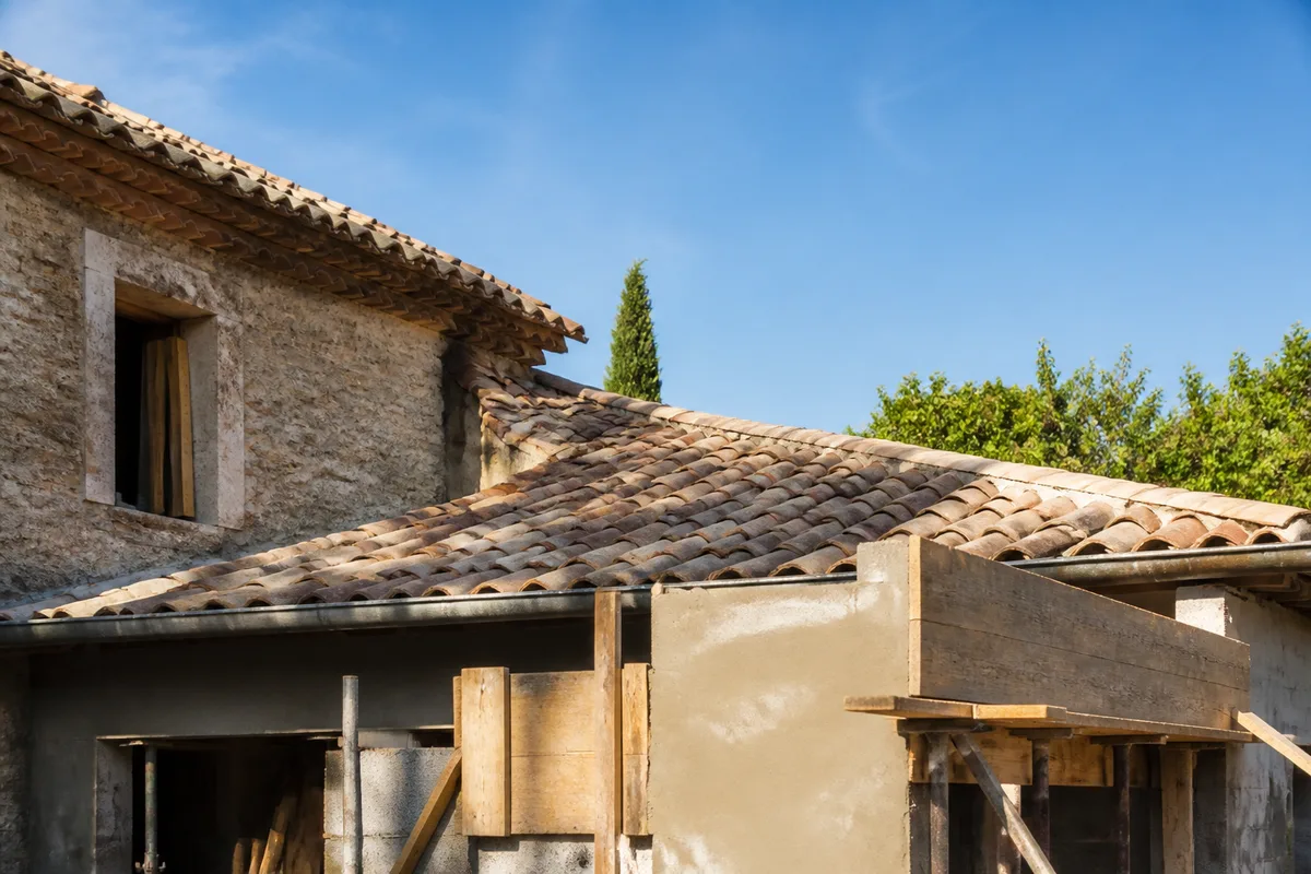Toiture en tuiles canal d’une maison ancienne sous le ciel de Provence